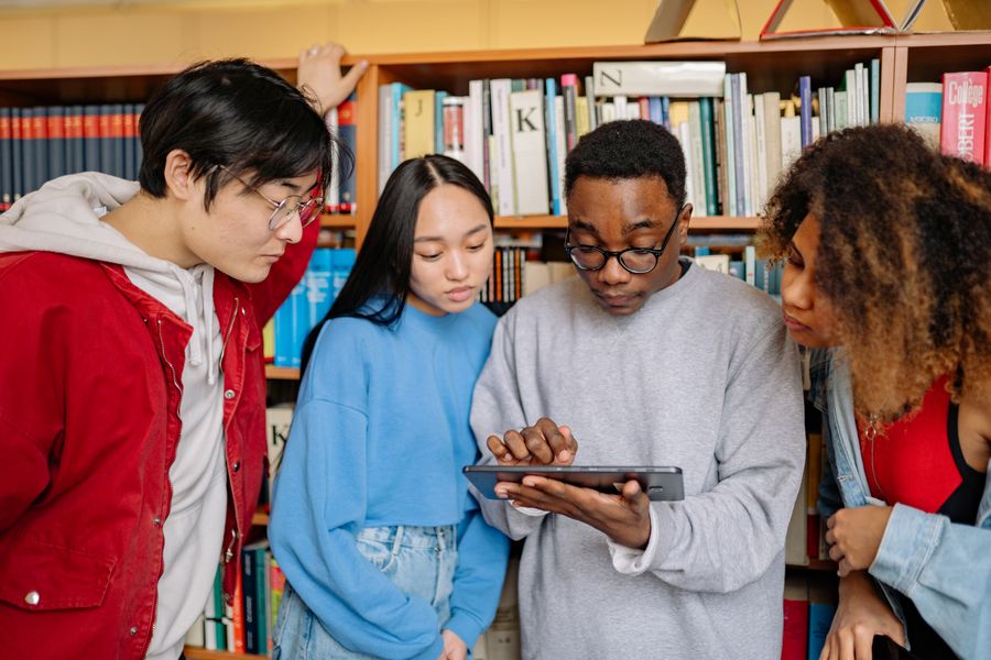 Estudiantes universitarios con tablet en biblioteca