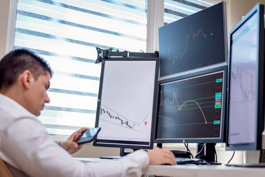 Trader financiero con monitores de alta tasa de refresco
